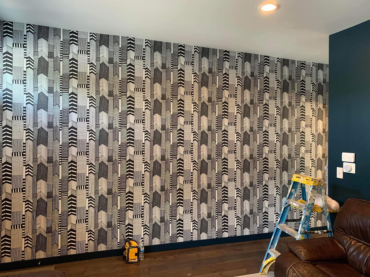 Wallpaper installer carefully working on a patterned wallcovering installation